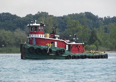 Tug Krista S. upbound with a barge secured and trailing her at a distance.