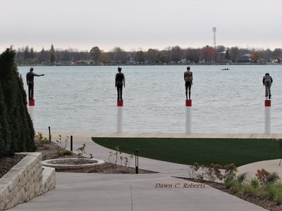Spotted these figures (as though walking on water) through the fence, but have no information on who they may represent.