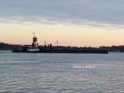 Tug Sarah Andrie catches the setting sun as she pushes her barge to Detroit.