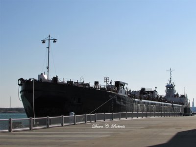 A bow-to-stern view, through the chain link fence.