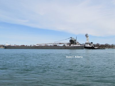 Tug Victory pushing barge Maumee under sunny skies, in mid  afternoon.