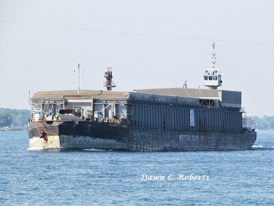 Tug Wilf Seymour (Sarnia) peering over the length of barge Alouette Spirit, above Marysville.